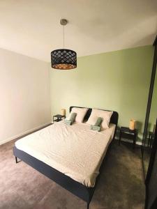 a bedroom with a bed and a pendant light at Au calme sur le canal et proche Disney in Vaires-sur-Marne