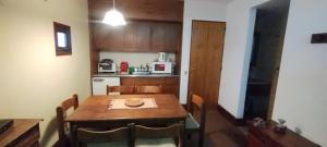 a kitchen with a wooden table and a table and chairs at Aconcagua Departamento in Los Penitentes