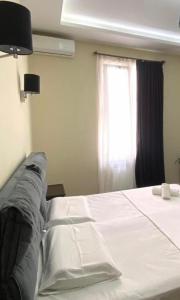 a bedroom with a white bed with a window at Guest House Kobuleti on Aghmashenebeli in K'obulet'i