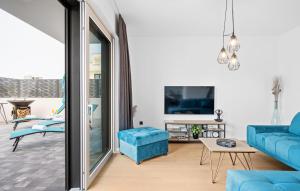 スリマにあるAwesome Home In Srimaの青いソファとテレビのあるリビングルーム