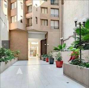 Un patio de un edificio con plantas en macetas. en Lujoso y Confortable Departamento de Valentina, en Santiago
