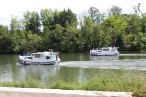 two boats in the water on a river at Calme au bord de l'eau in Laroche-Saint-Cydroine +1 photo