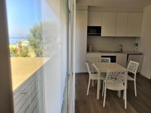 a kitchen and dining room with a table and chairs at "Le chic" sulla duna fronte mare in Follonica +19 photos