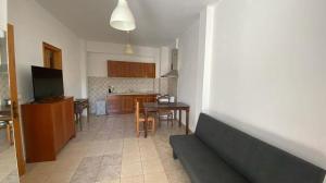 a living room with a couch and a kitchen at Areopoli Apartment in Areopolis
