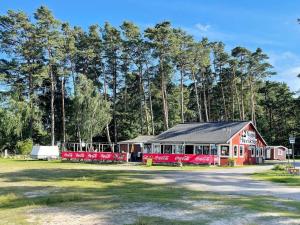 a red and white building with trees in the background at 4 star holiday home in SÖLVESBORG in Sölvesborg