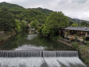 a river with a waterfall next to a building at 嵐天RanTen in Shimo saga