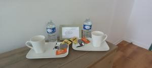 a table with two cups and two bottles of water at le studio de Dalie in Honfleur