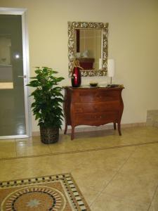 a room with a dresser with a mirror and a plant at Hotel San Martino in Cassibile