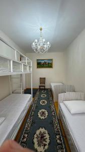 a bedroom with two beds and a chandelier at Дом 14 in Osh +52 photos