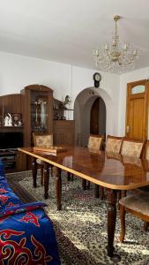 a dining room with a large wooden table and chairs at Дом 14 in Osh