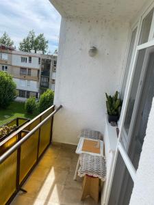 einen Balkon mit einem Tisch und einer Bank in der Unterkunft Digitális Detox Apartman in Tiszafüred