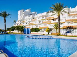 a swimming pool in front of a large white building at LMHA25, Puerto Latino 11, Tomas Maestre Marina, La Manga in La Manga del Mar Menor