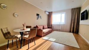 Una sala de estar con un sofá, una mesa y sillas. en Arman, en Kokshetau