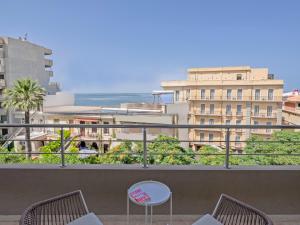 a balcony with two chairs and a table and some buildings at Space Row Design Living in Heraklio