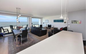 Una sala de estar con una mesa y sillas y el océano. en Residentie Vent De Sable R116, en Ostende