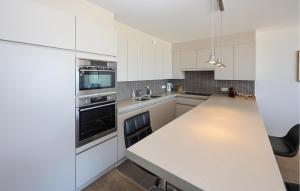 Una cocina con gabinetes blancos y una encimera blanca. en Residentie Vent De Sable R116, en Ostende
