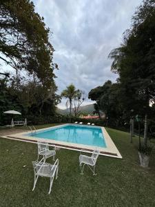 ペトロポリスにあるVilla do Lago Nogueiraのスイミングプール(椅子2脚、テーブル付) +17枚の写真