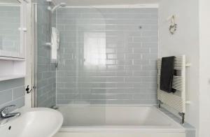 ein Badezimmer mit einer weißen Badewanne und einem Waschbecken in der Unterkunft Beautiful Sea Front Cottage in the Ocean City in Plymouth