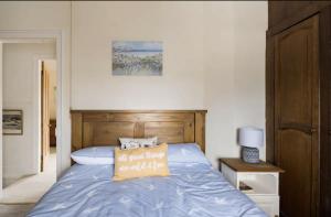 ein Bett mit einer blauen Bettdecke und einem Kissen darauf in der Unterkunft Beautiful Sea Front Cottage in the Ocean City in Plymouth