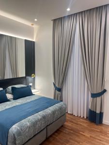 a bedroom with a blue bed and curtains at La Lepre felice-bovio in Naples