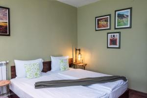 a bedroom with two beds and pictures on the wall at Къща за гости Саша in Krapets +51 photos