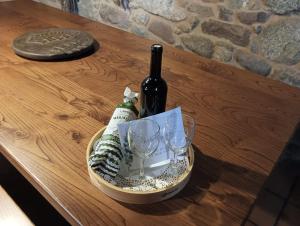 a bottle of wine and glasses on a table at Lareira rural apartamento Ribeira Sacra Chantada in Chantada +12 photos