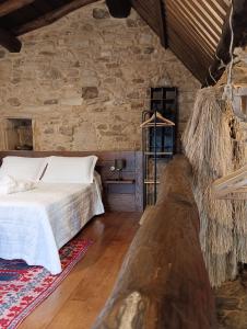 a bedroom with a bed and a stone wall at Lareira rural apartamento Ribeira Sacra Chantada in Chantada