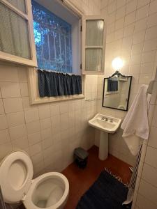 ペトロポリスにあるVilla do Lago Nogueiraのトイレ、洗面台、窓のあるバスルーム