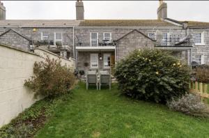 ein großes Backsteinhaus mit einem Hof mit zwei Büschen in der Unterkunft Beautiful Sea Front Cottage in the Ocean City in Plymouth