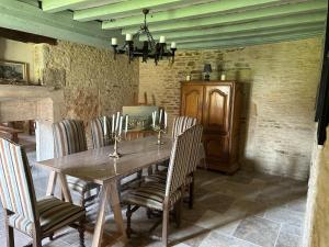 a dining room with a wooden table and chairs at la bastille de Forfot in Ampilly-le-Sec