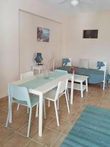 a dining room with a table and chairs and a couch at Themelis Apartment II in Kalymnos