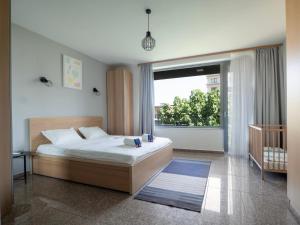 a bedroom with a bed and a large window at Vertigo 2 Modern 2-Bedroom Apartment with Parking & Vitosha View in Sofia