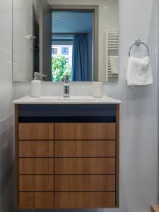 a bathroom with a sink and a mirror at Vertigo 2 Modern 2-Bedroom Apartment with Parking & Vitosha View in Sofia +32 photos