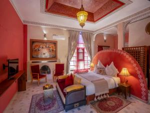 ein Schlafzimmer mit einem großen Bett und einem Kamin in der Unterkunft Riad Clé De Sol & SPA in El Jemʼa Ghemat