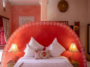ein Bett mit rotem Kopfteil und zwei Lampen in der Unterkunft Riad Clé De Sol & SPA in El Jemʼa Ghemat + 246 Fotos