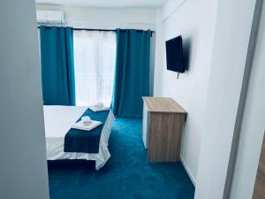 a small room with a bed and a television at Sunrise Boutique in Costinesti