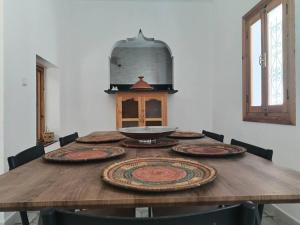 a wooden table with nine plates on top of it at El Sama' family house Rooftop 80m2 in Chefchaouen