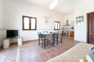 una cucina e una sala da pranzo con tavolo e sedie di Rosemarine Corda a Favignana