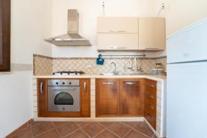 una cucina con mobili in legno e una stufa di Rosemarine Corda a Favignana