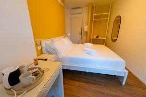 a small bedroom with a white bed and a mirror at Near Vatican, Irnerio 47 Guest House in Rome