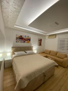 a bedroom with a large bed and a couch at Comfort studio Lepa Kata in Podgorica