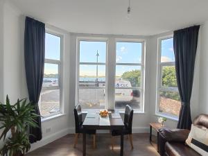 a living room with a table and some windows at Lakeside View in Southport