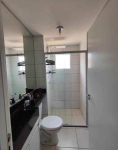 a bathroom with a toilet and a glass shower at Apartamento confortável in Campo Grande