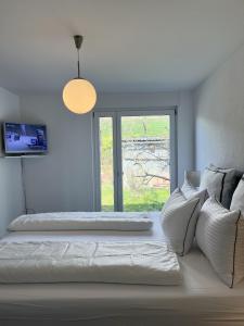 シュテューリンゲンにあるFerienhaus Cris und Alexのベッドが2つと窓がある白い部屋