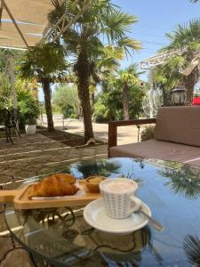 a table with a plate of food and a cup of coffee at Hotel Velipoja Park in Velipojë