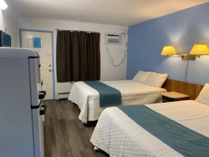 a hotel room with two beds and a window at Swiss Sunset Inn in Penticton +37 photos