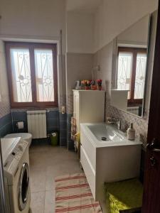 a bathroom with a sink and a washing machine at Sole ampi spazi quiete John apartaments in Ciampino