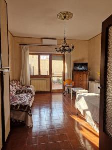 a living room with a bed and a couch at Sole ampi spazi quiete John apartaments in Ciampino