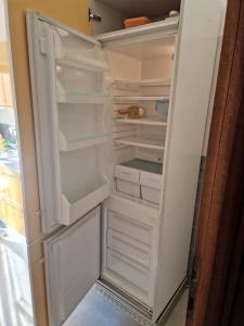 a white refrigerator with its door open with its door open at Sole ampi spazi quiete John apartaments in Ciampino