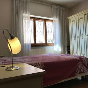 a bedroom with a bed and a lamp on a table at Sole ampi spazi quiete John apartaments in Ciampino +22 photos